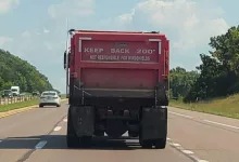 Dumptruck with sign stating the driver is not responsible for broken windshields"